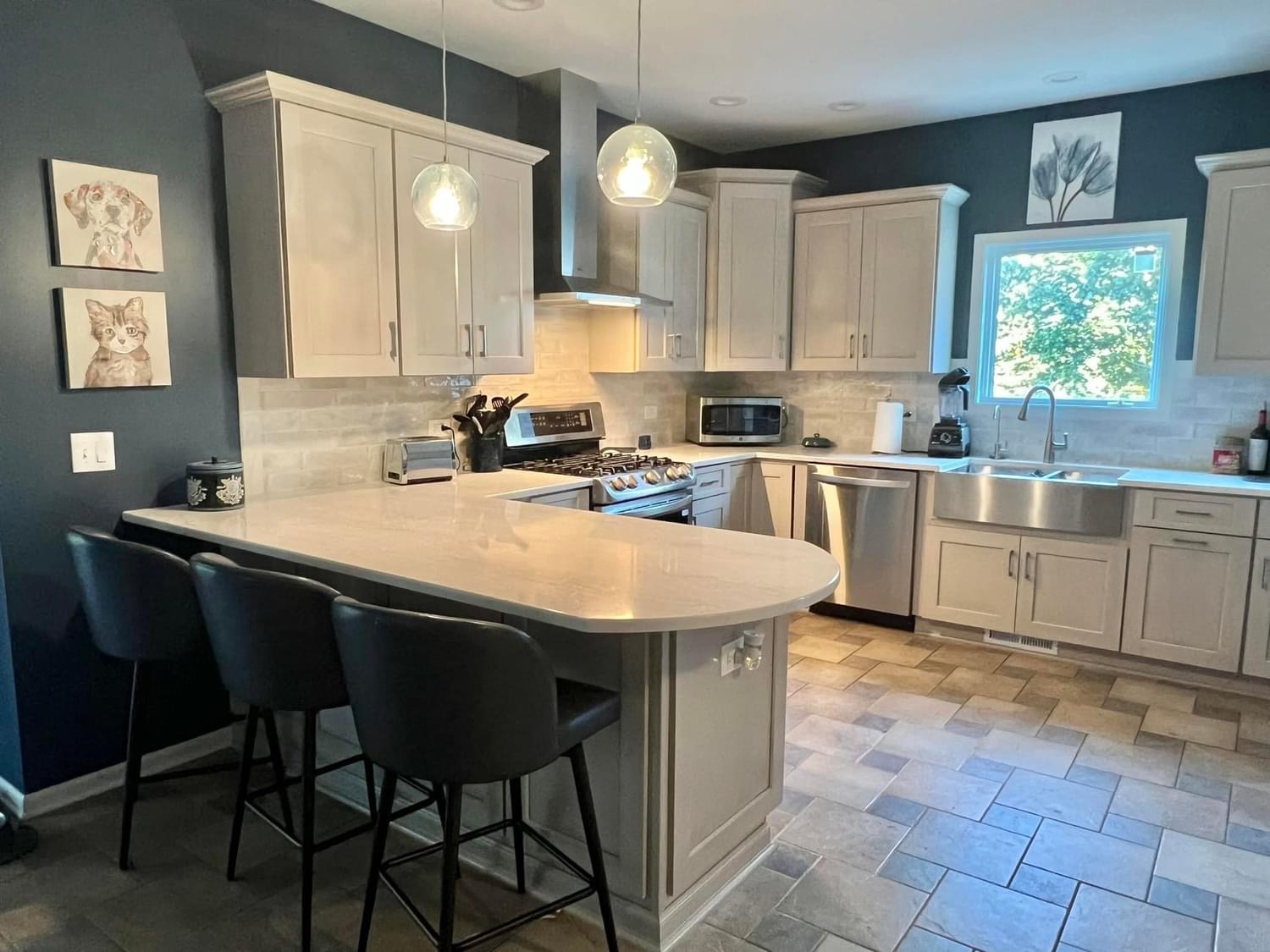 A kitchen with white cabinets and black chairs