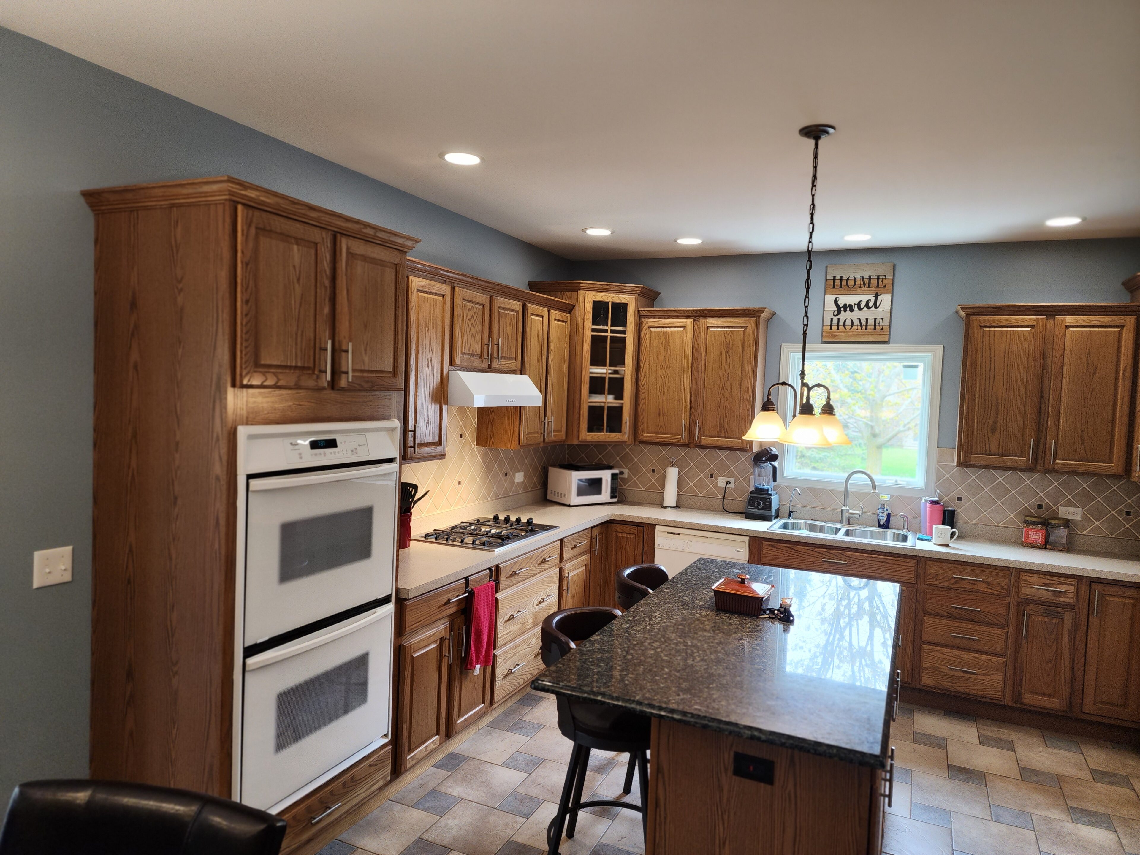 A kitchen with wooden cabinets and white appliances.