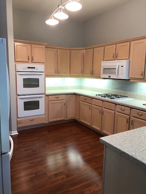 A kitchen with wooden cabinets and white appliances.