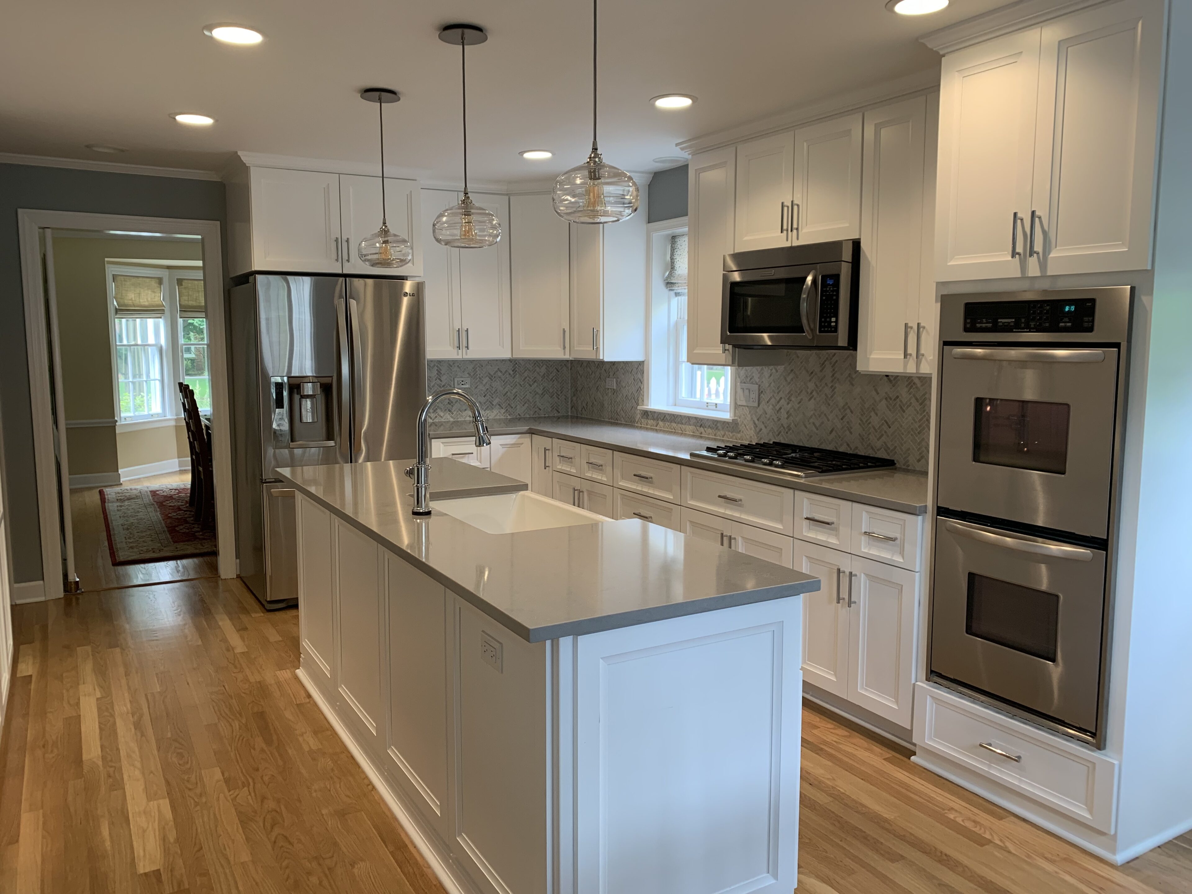 A kitchen with white cabinets and stainless steel appliances.