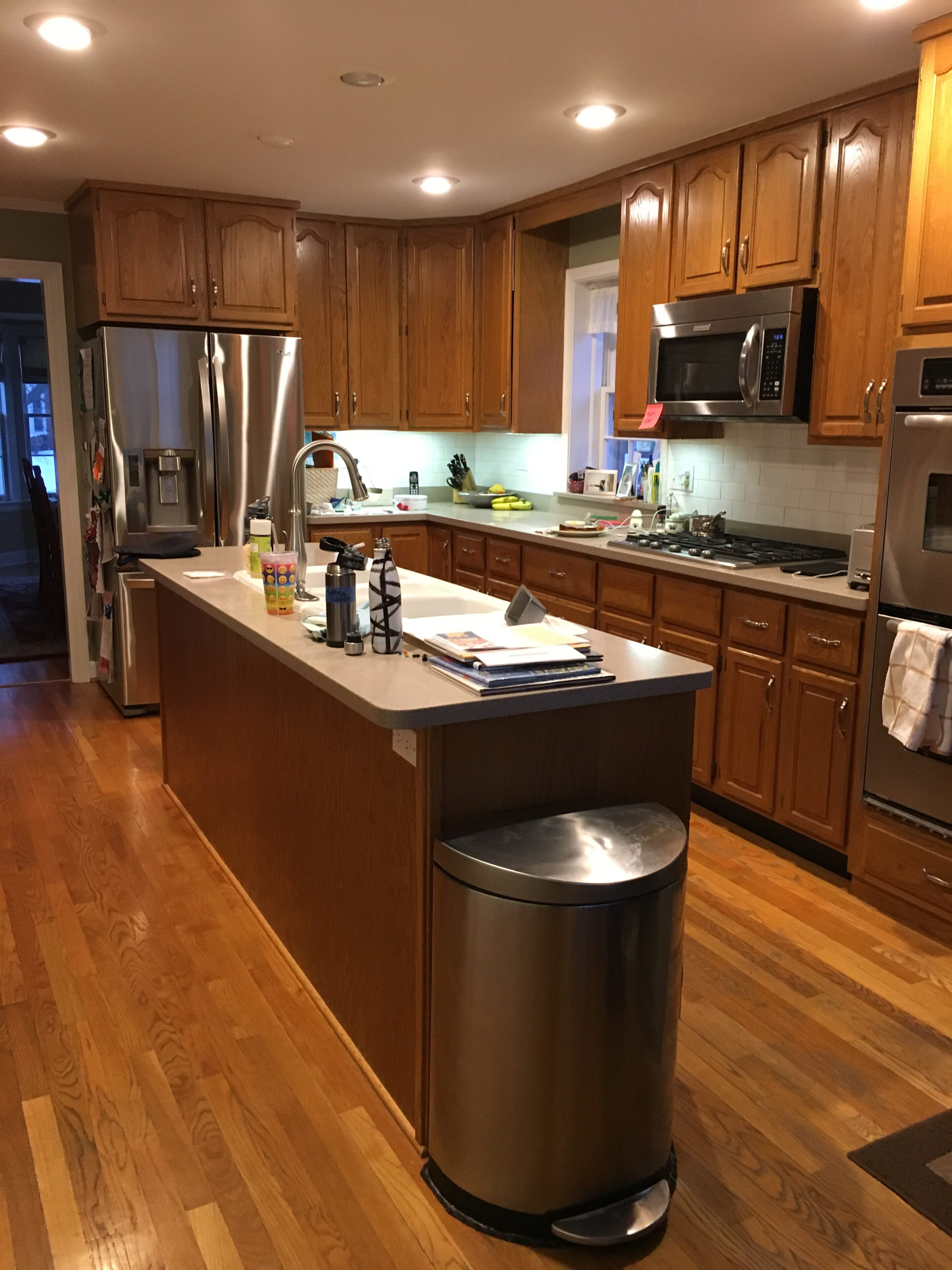 A kitchen with wood floors and stainless steel appliances.