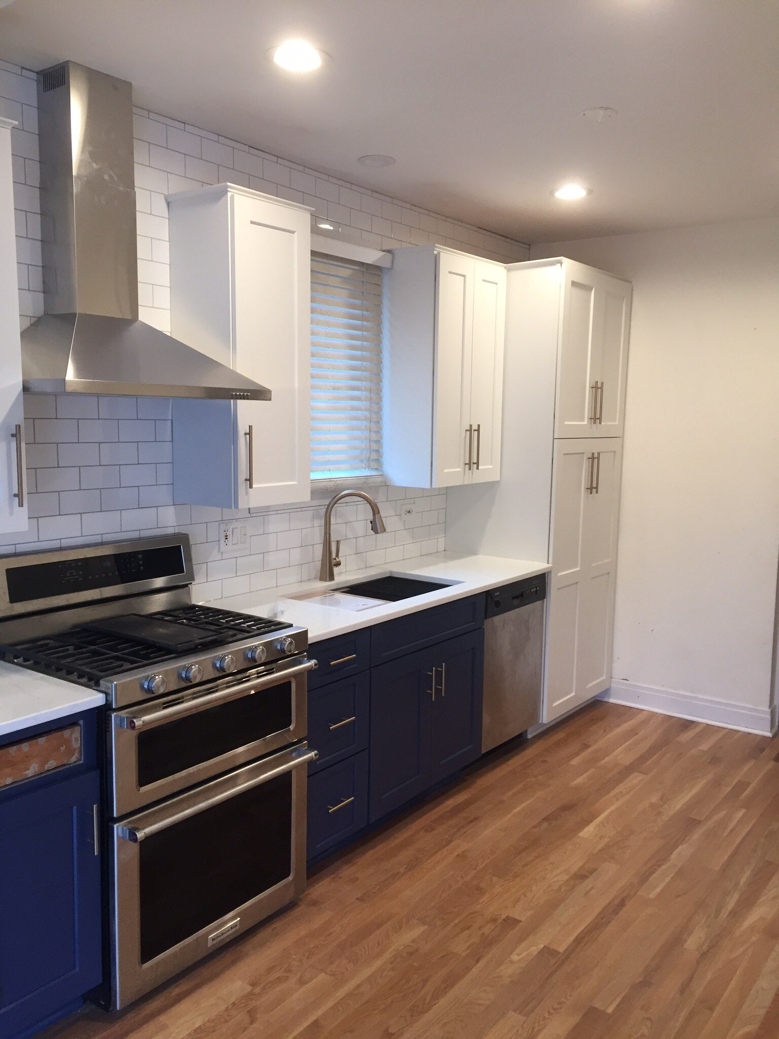 A kitchen with blue cabinets and white walls.