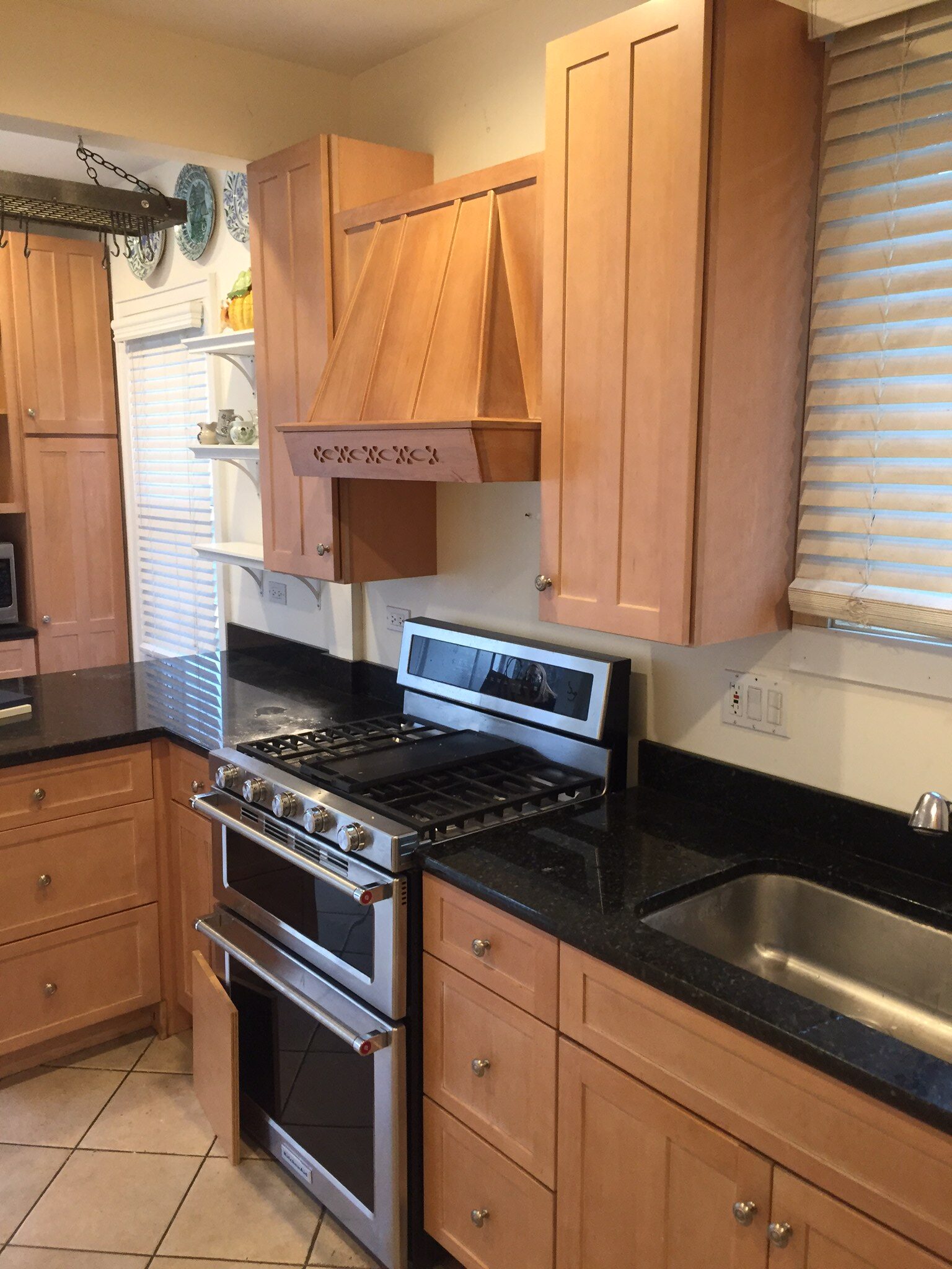 A kitchen with wooden cabinets and black counter tops.