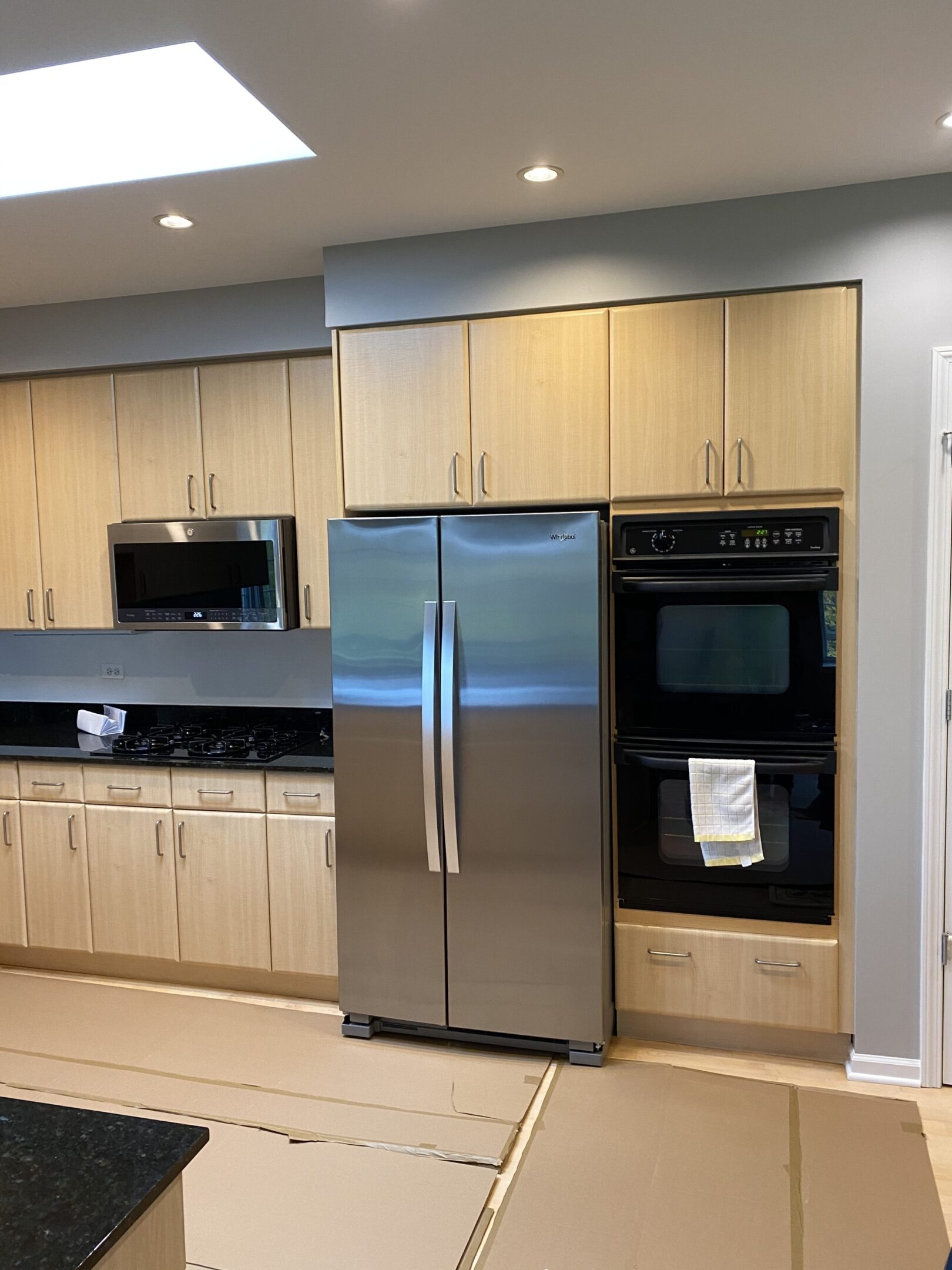 A kitchen with stainless steel appliances and wooden cabinets.