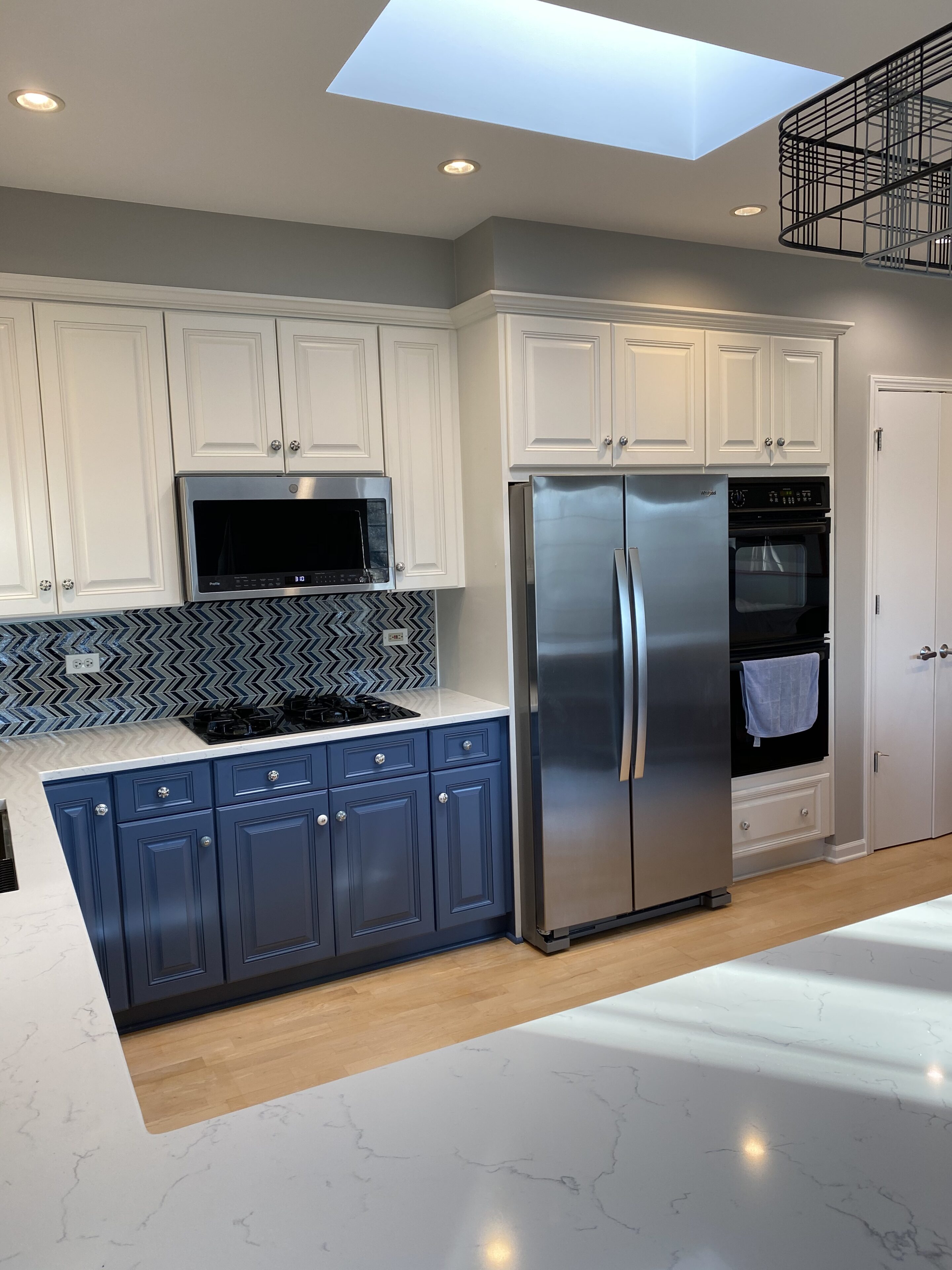 A kitchen with white cabinets and blue painted doors.