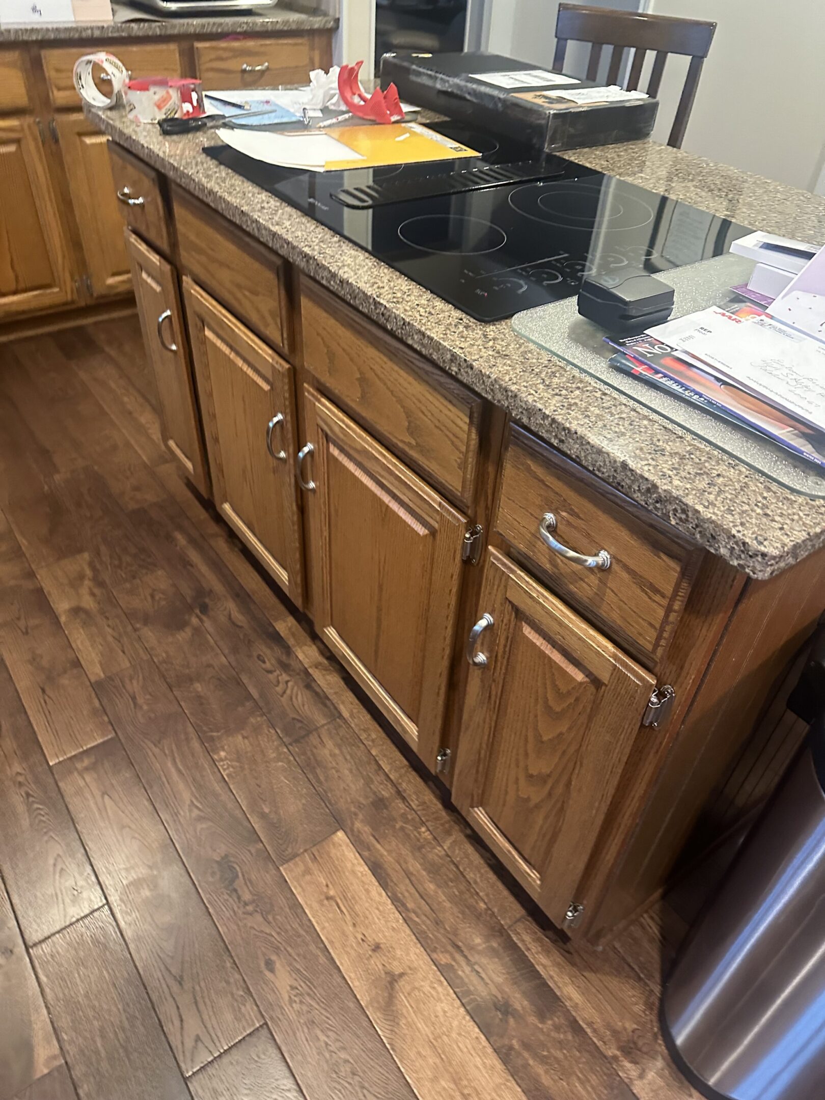 A kitchen with wooden cabinets and wood floors.