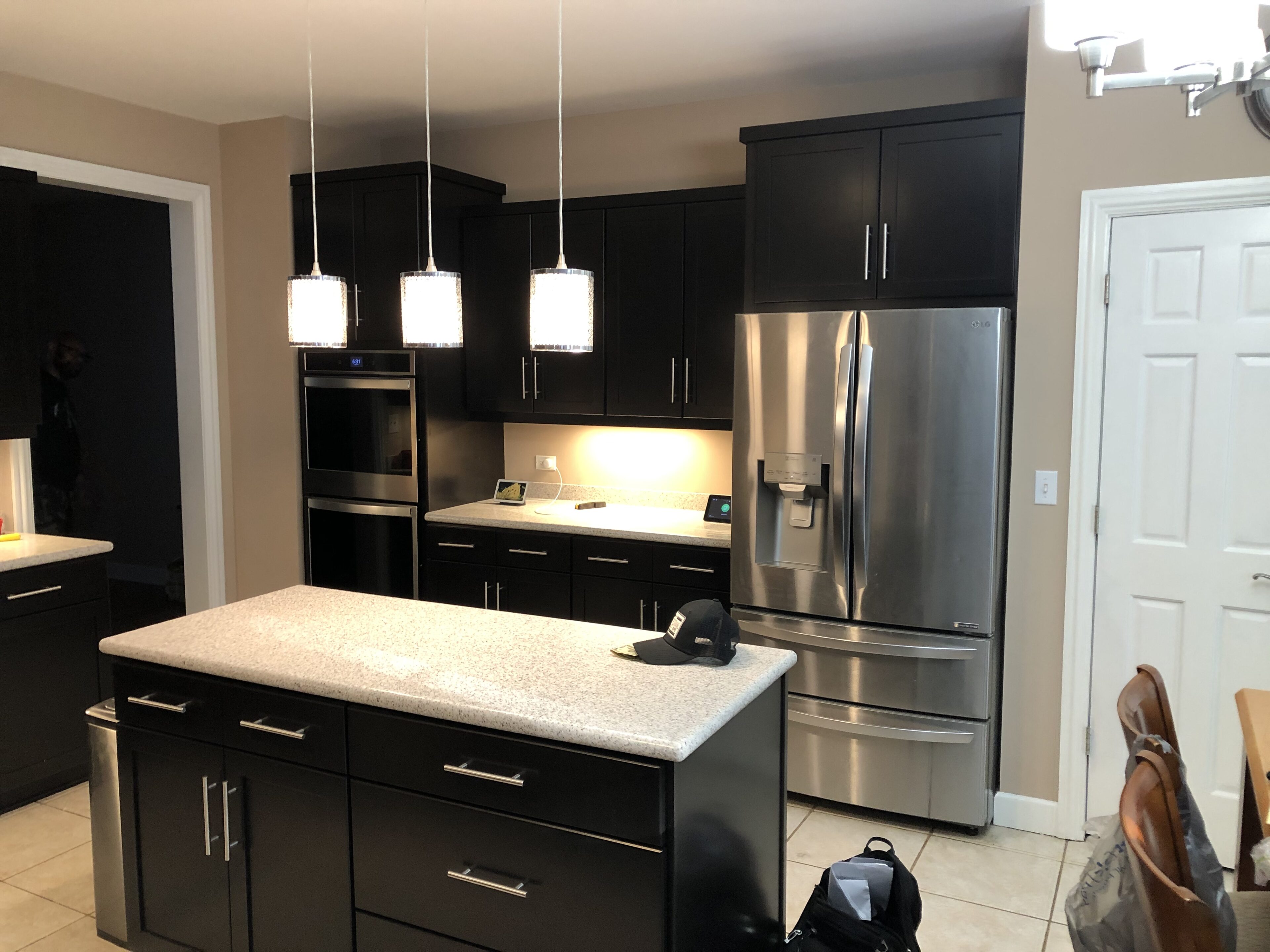 A kitchen with black cabinets and stainless steel appliances.