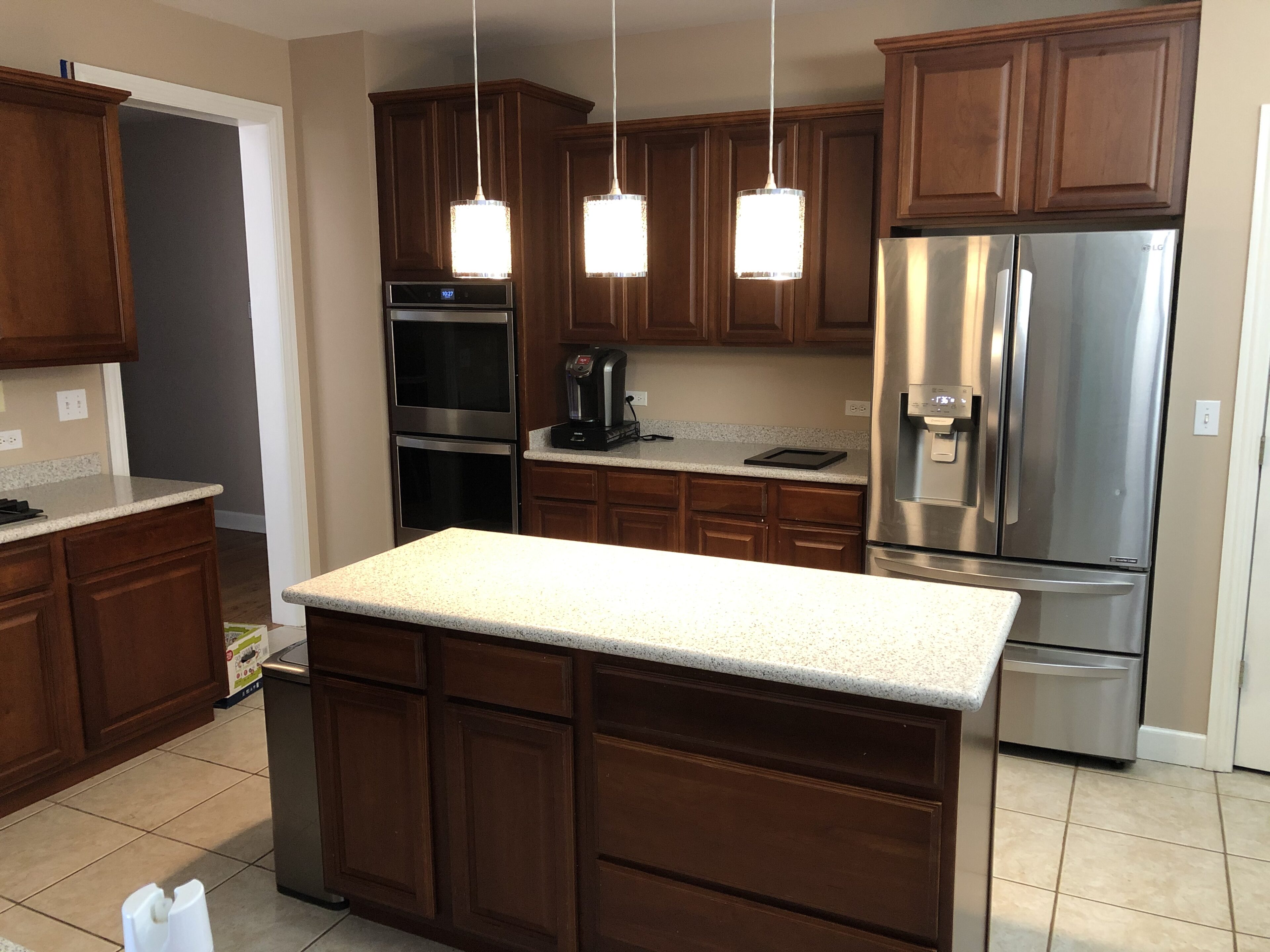 A kitchen with brown cabinets and white counter tops.