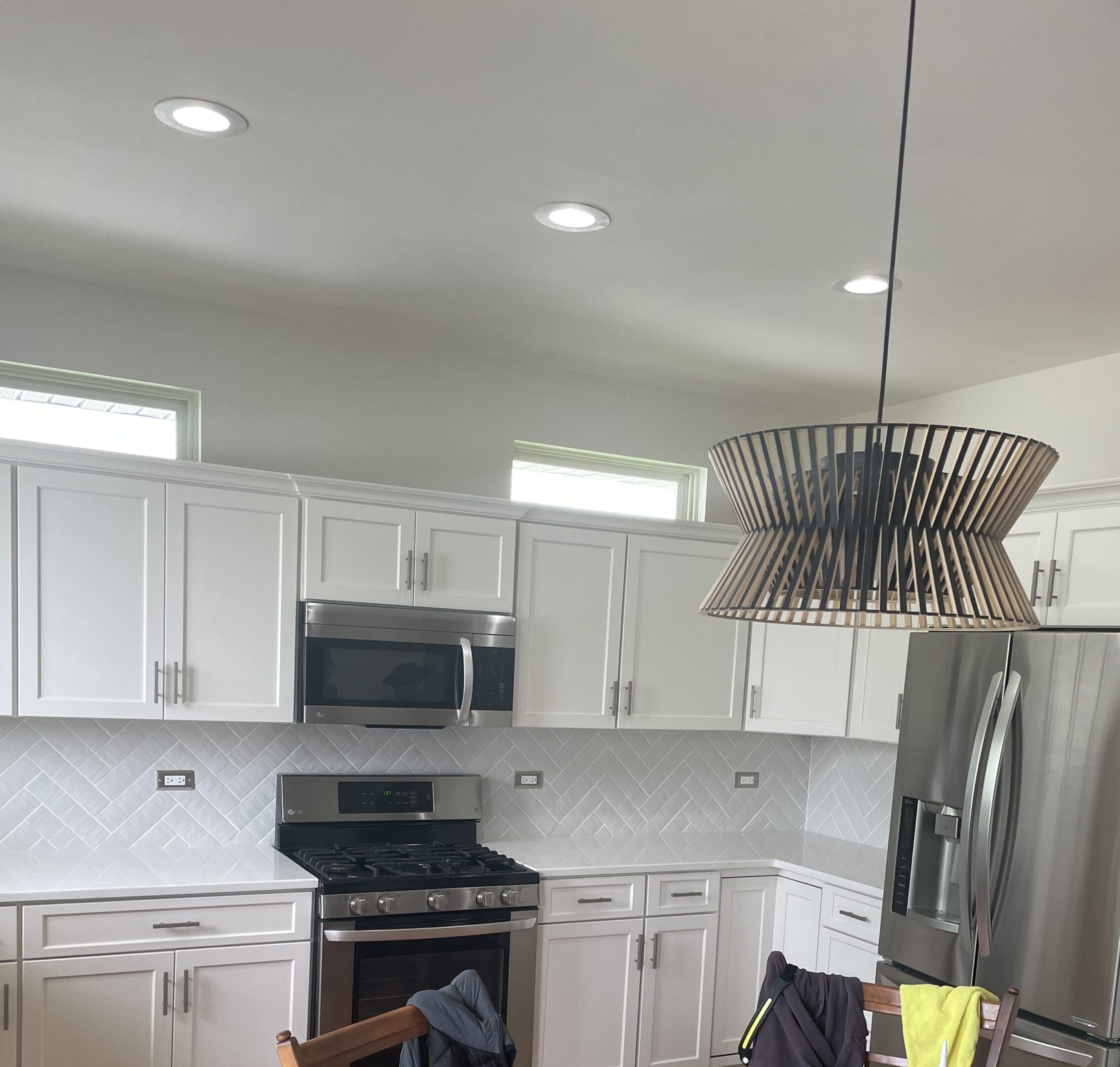 A kitchen with white cabinets and black appliances.