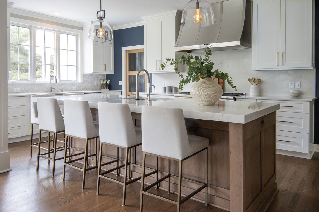 A kitchen with white cabinets and wooden floors